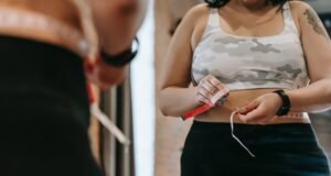 ¿Por qué engordamos en pandemia? woman measuring waist with tape in gym