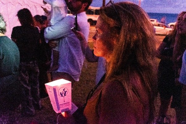 Mujer es iluminada por la luz de una vela en el rosario por la familia