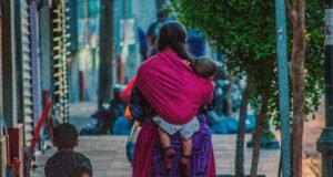 Economía del Cuidado: Su impacto real en la vida de las mujeres mujer de la economía del cuidado cuidando a sus hijos y trabajando