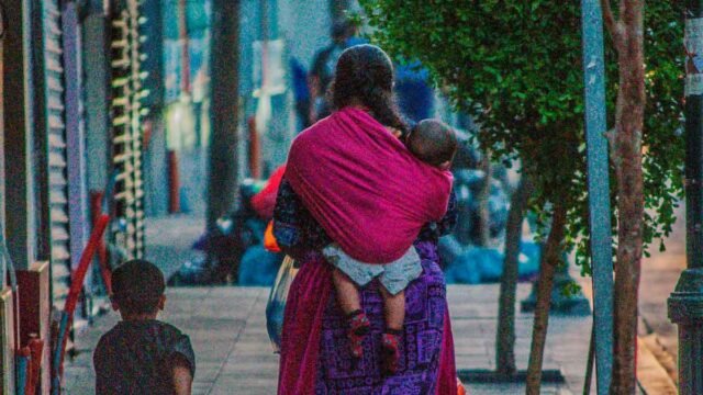 dux-camp-mujer-economia-cuidado mujer de la economía del cuidado cuidando a sus hijos y trabajando